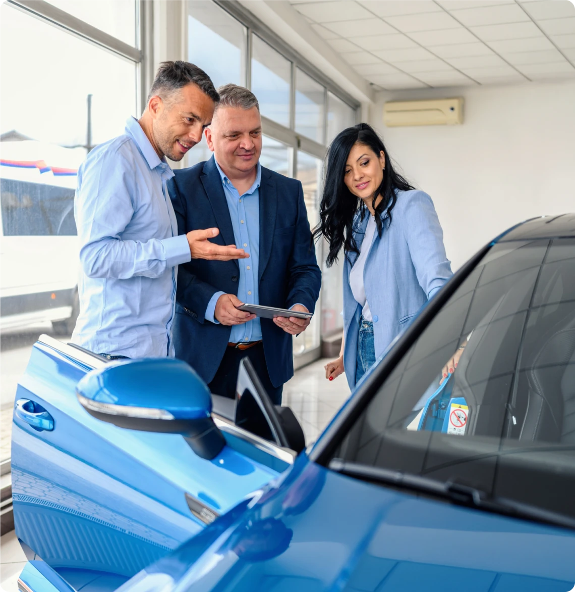 People discussing next to new blue car