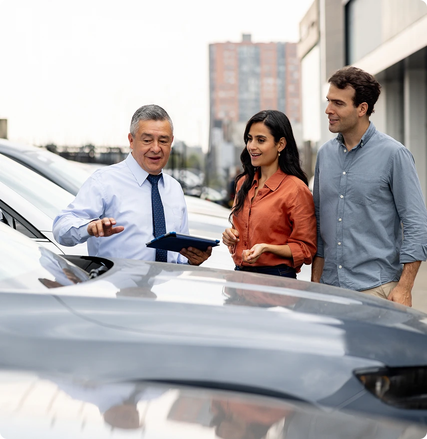 Car salesperson discussing vehicle options with couple